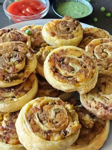 Buttery flaky Samosa Puff Pastry pinwheels served with ketchup and mint chutney.