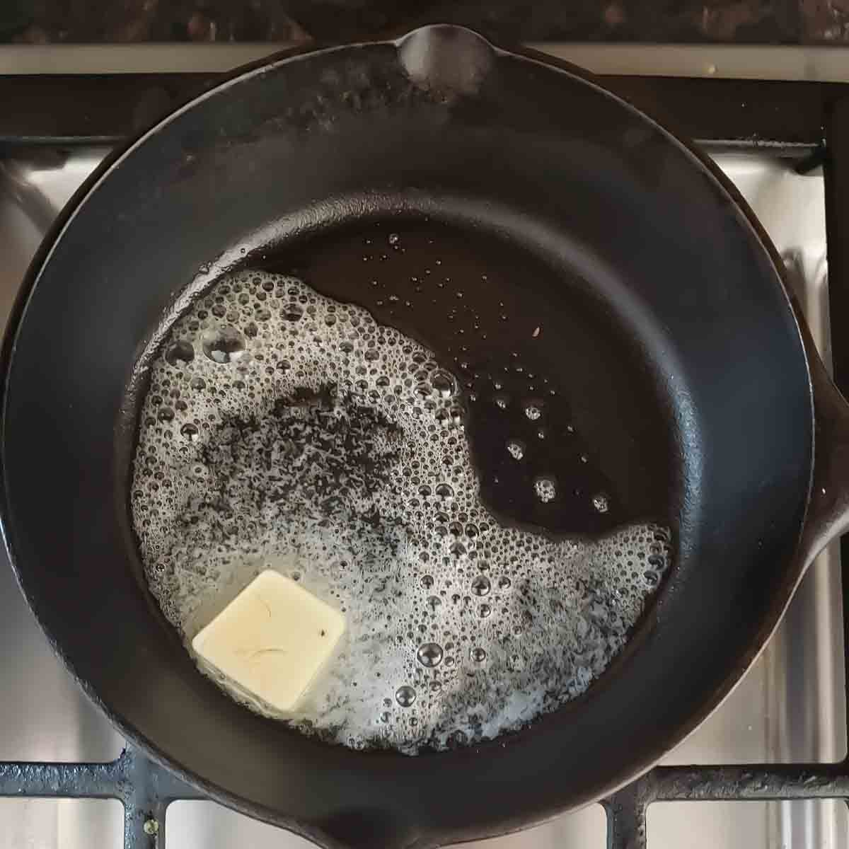 Melting butter in cast iron skillet to make the sauce base.