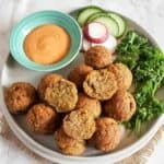 Baked falafel made with chickpeas and herb seasoning served as a middle Eastern Appetizer with dipping sauce.