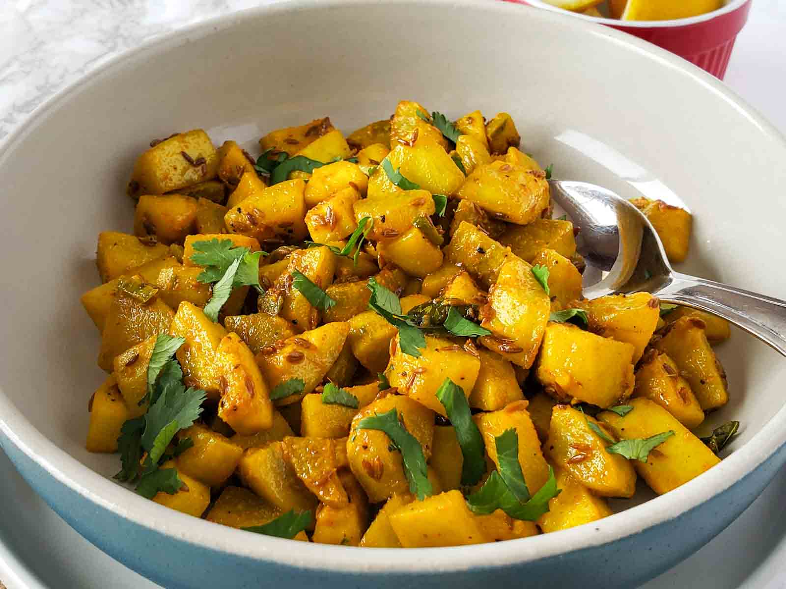 Golden brown lauki curry spiced with turmeric and chili powder.