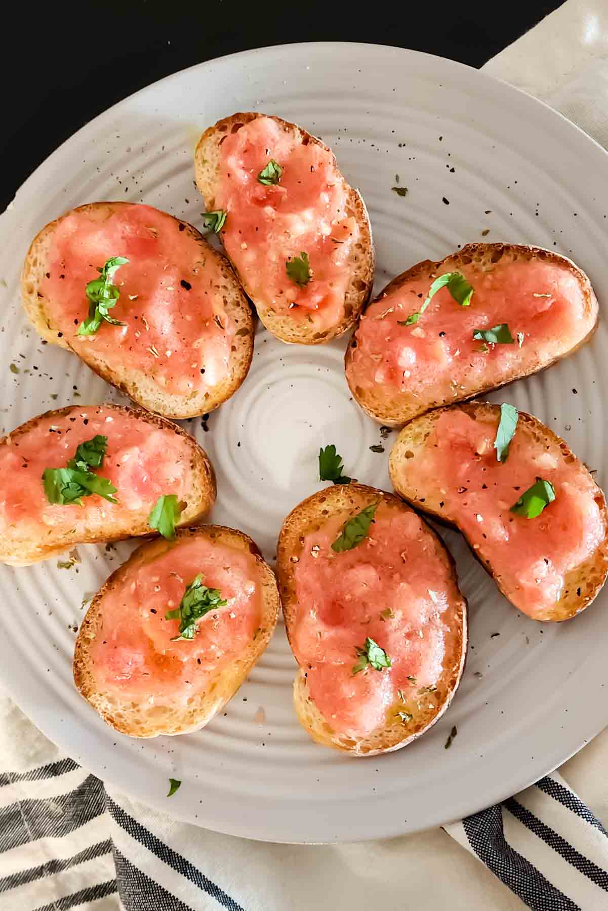A serving platters with Spanish tomato bread arranged on it. 