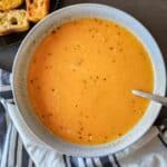 Creamy roasted vegetable soup with coconut milk served in a bowl.