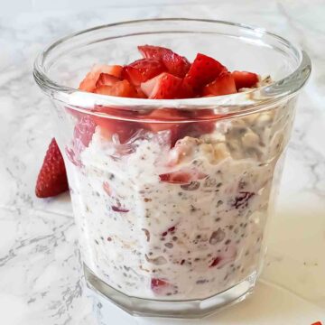 A glass jar filled with Strawberries and cream overnight oats.