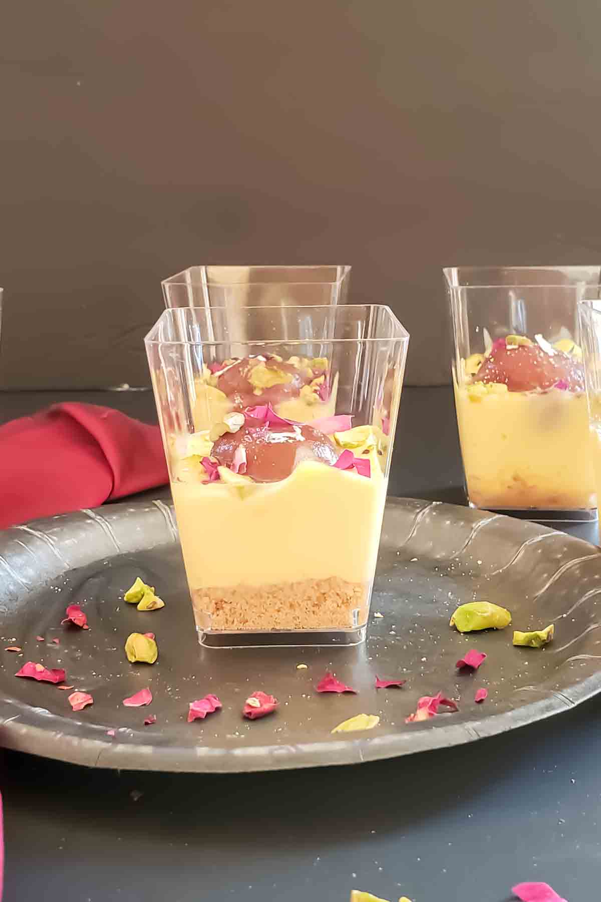 A dessert cup filled with gulab jamun trifle with custard recipe.