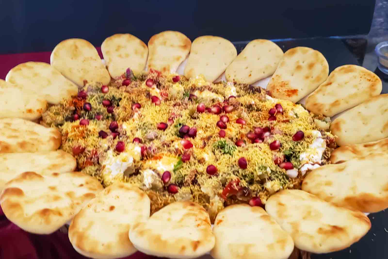 Indian Chaat Board with 7 different layers served with naan dippers for party appetizer.
