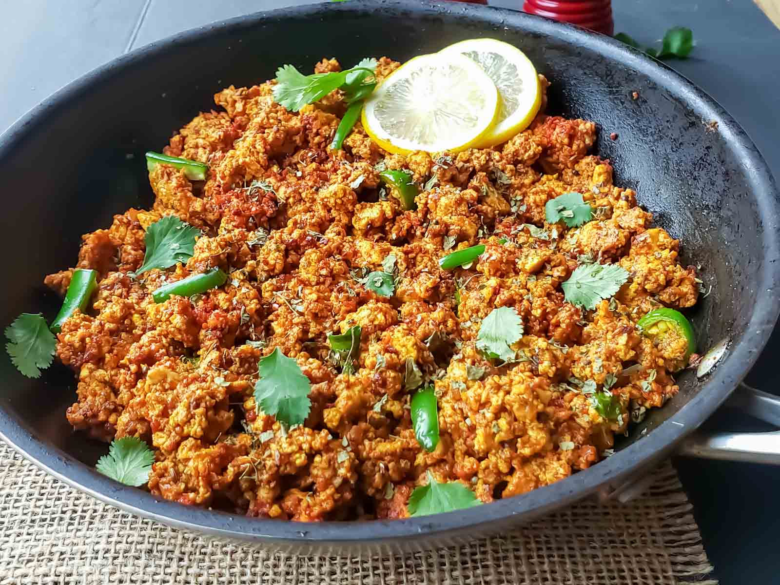 Crumbled spiced paneer Bhurji served with garnishes for breakfast.