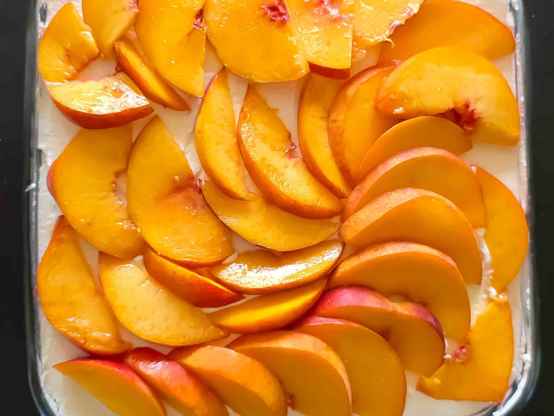 Rich peach and cream cheesecake ready to serve.