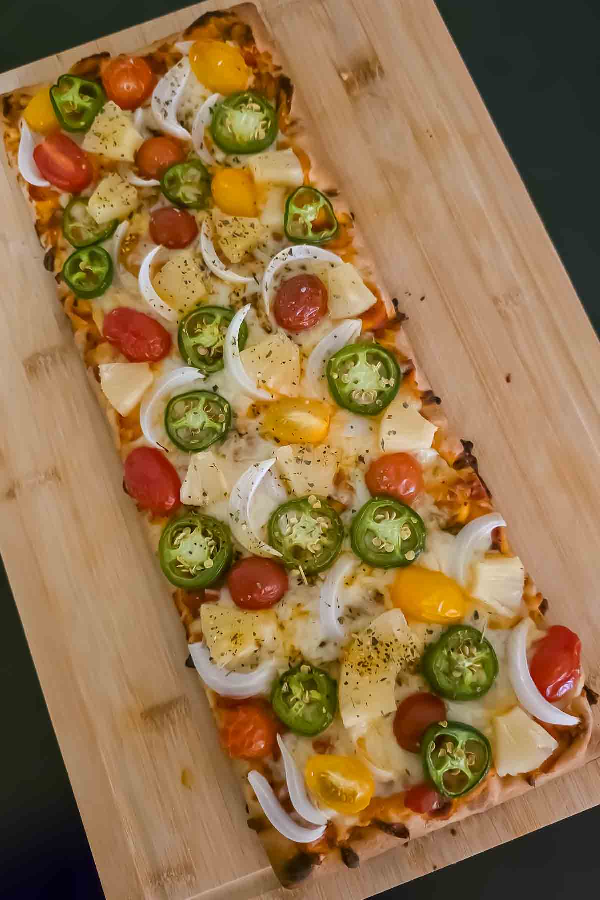 Pineapple jalapeño flatbread pizza topped with melted mozzarella and baked until golden.