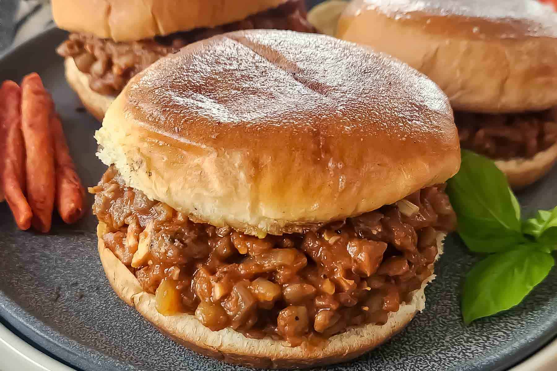Close-up of a wholesome lentil sloppy joe sandwich with a rich tomato-based sauce.