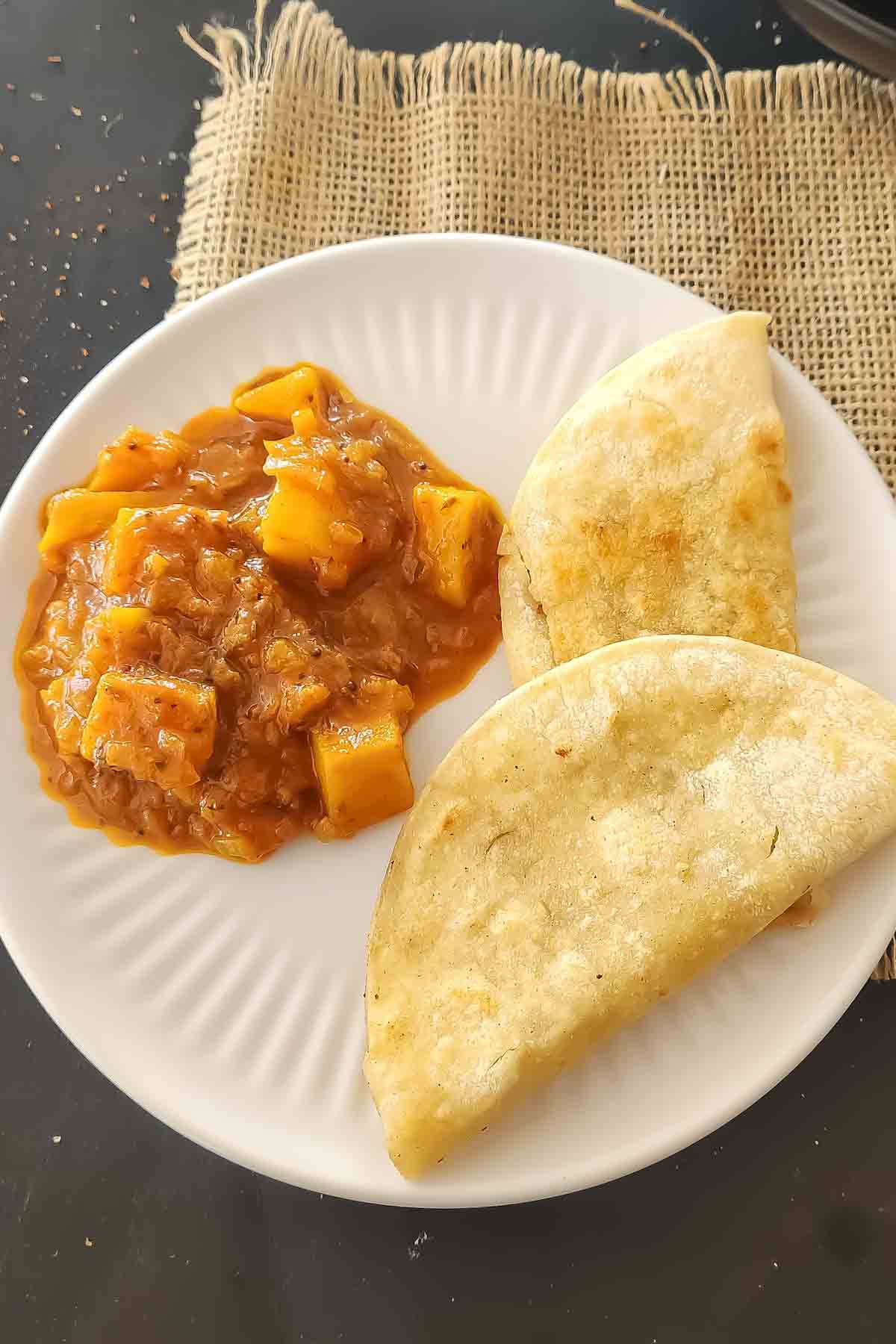 A plate with vindaloo curry and roti served for dinner.