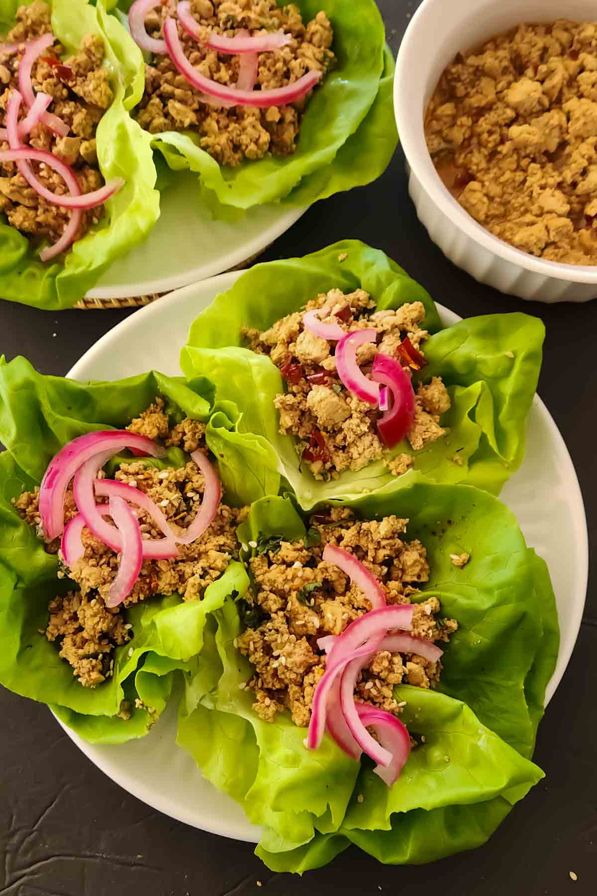 Make easy tofu lettuce wraps with savory miso, spicy ginger sauce, and garlic. Serve in crisp butter lettuce cups with pickled red onions and sesame seeds.