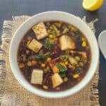 Tofu soup with frozen vegetables, miso, ginger and garlic in a bowl.