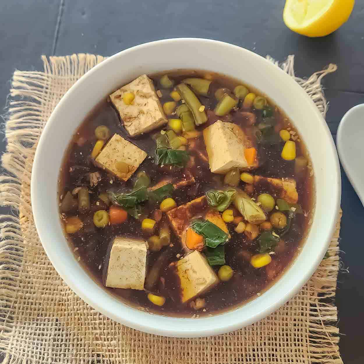 Tofu soup with frozen vegetables, miso, ginger and garlic in a bowl.