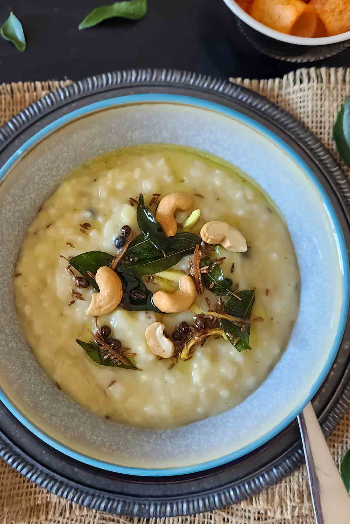 Ven Pongal recipe with rice, moong dal, black pepper, cumin, and cashews.] served for Indian meals.
